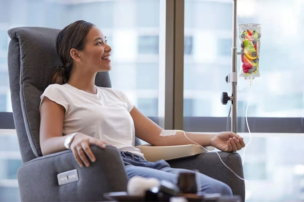 A woman enjoying an IV therapy session with a hydration drip, promoting wellness and revitalization.