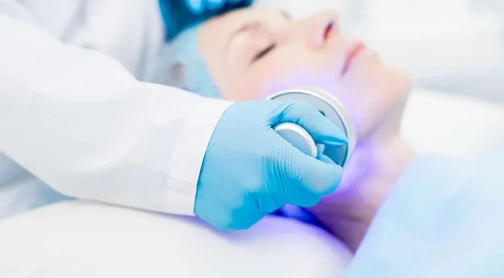 A medical professional applies a laser treatment to a patient’s face, enhancing skin health and wellness.