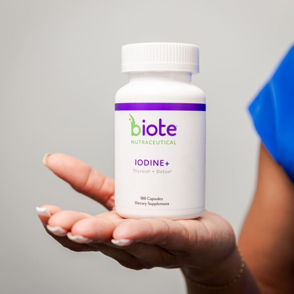 A hand holding Biote Iodine+ supplement, promoting thyroid health and detox for Skin Rejuvenations.
