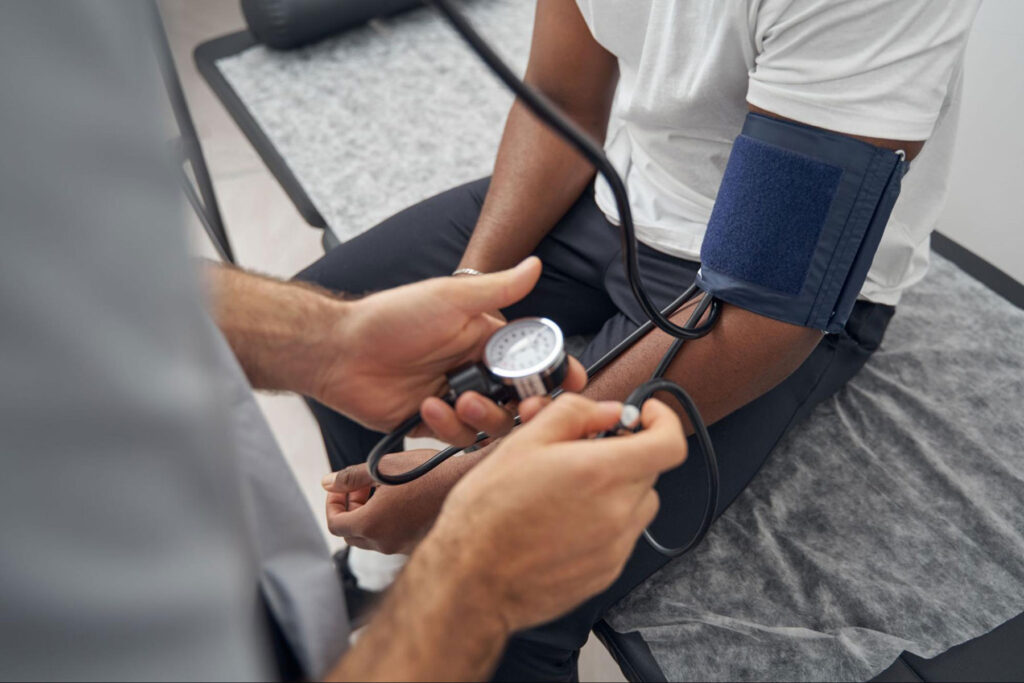 A healthcare professional measuring blood pressure during a DOT physical exam as part of FMCSA health standards.